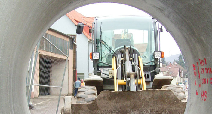 Blick durch ein Kanalrohr auf Baustelle