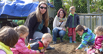 Kinder und Erwachsene spielen im Sandkasten