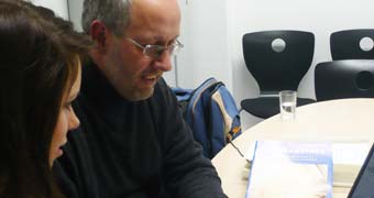 Frau und Mann im Gespräch an einem Tisch sitzend